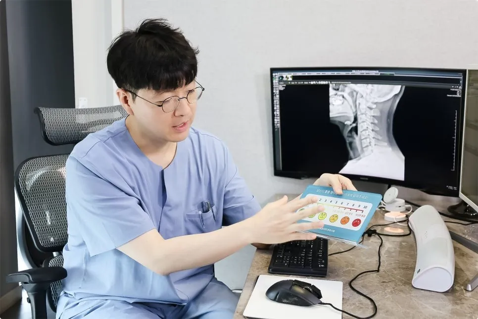 차경남 원장이 환자의 경추 엑스레이를 보며 통증 정도를 설명하는 모습