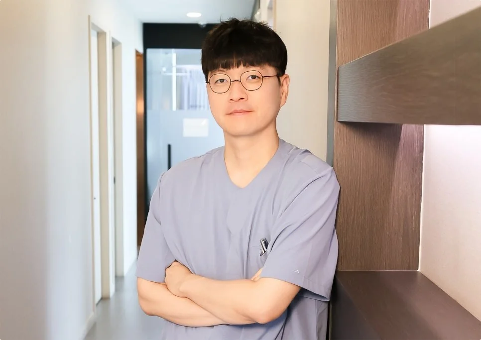 차경남 원장이 진료복을 입고 병원 복도에서 팔짱을 낀 모습